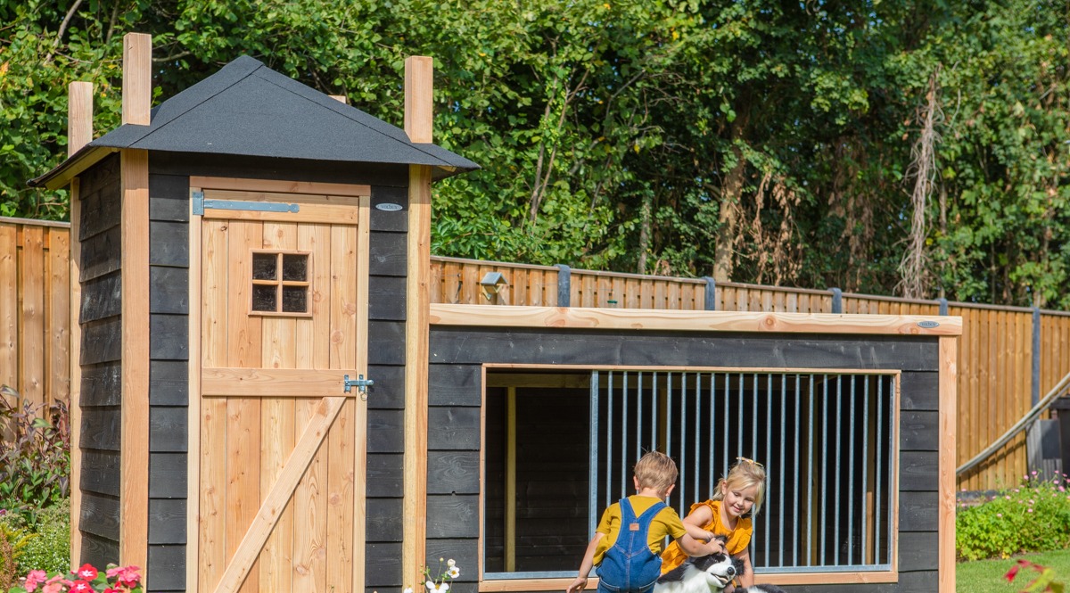 Voldux hondenkennel met nachthok in de tuin met spelende kinderen en border collie